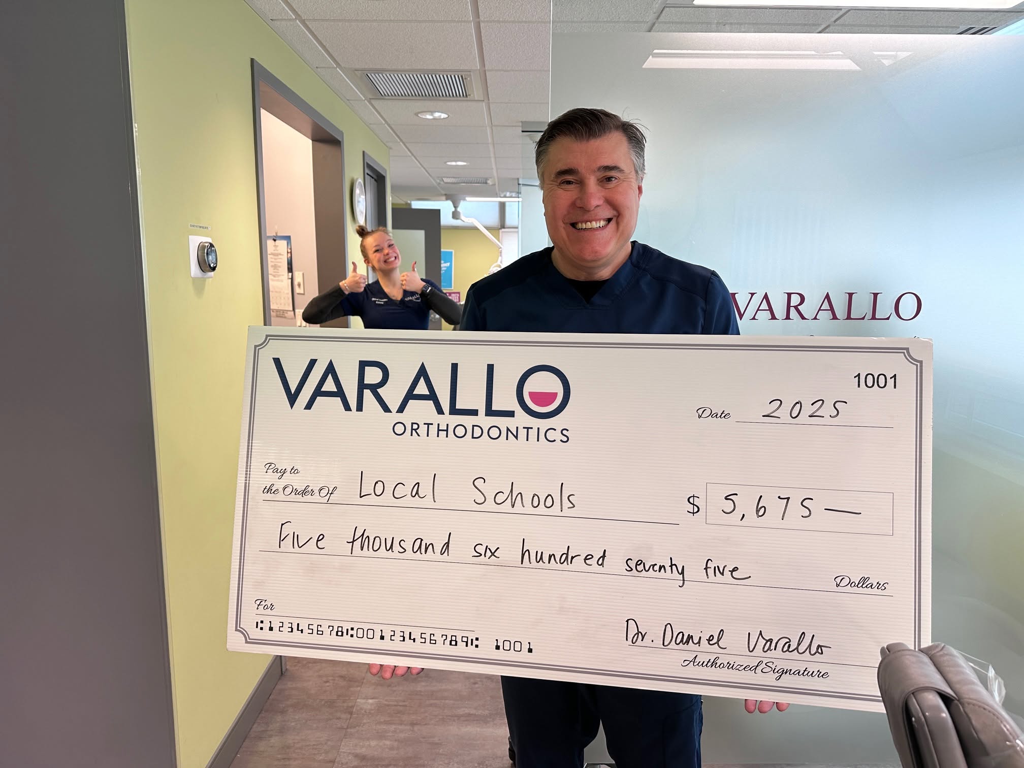 Dr. Varallo presenting a donation to a local school